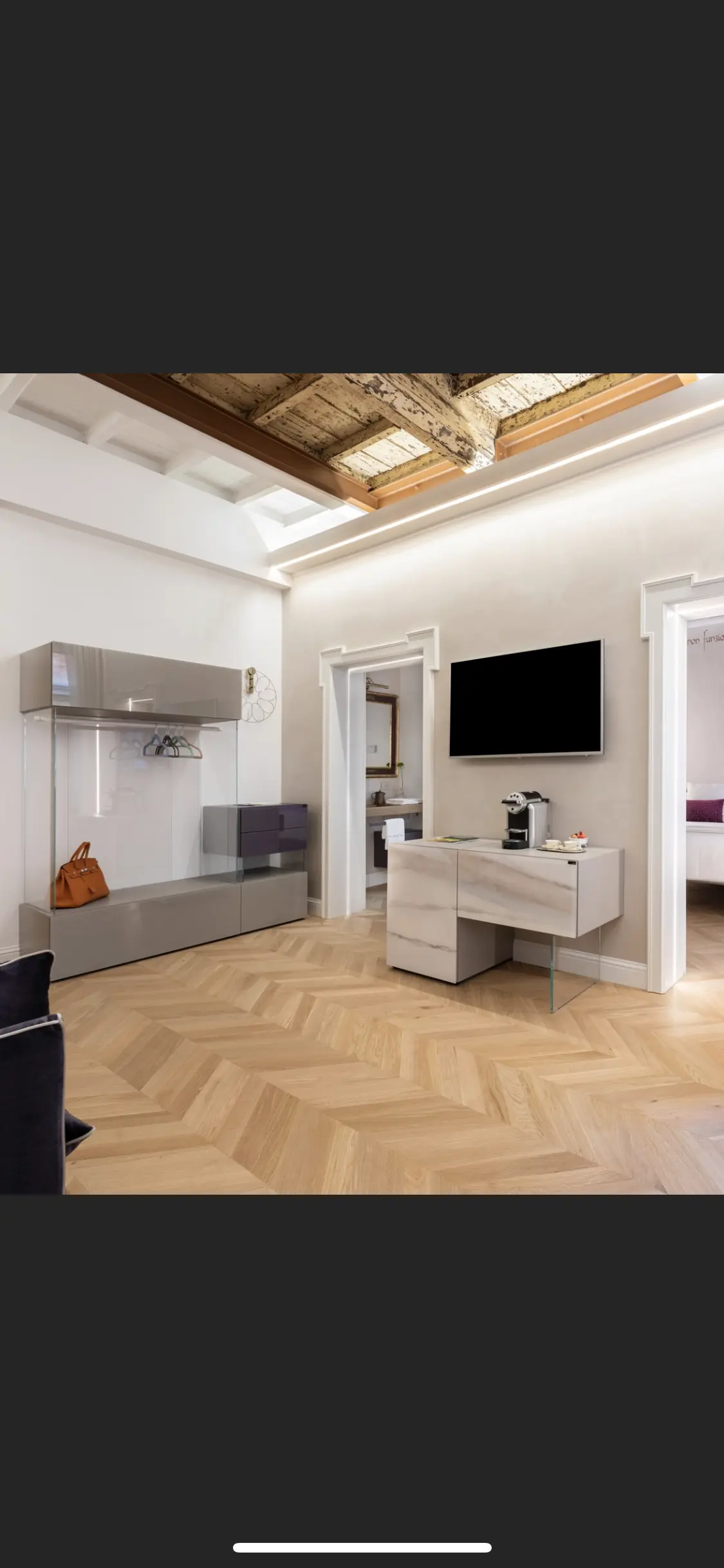 Zona guardaroba con ante in vetro e cassettiera laccata Vista della suite con cabina armadio a vista e comò laccato