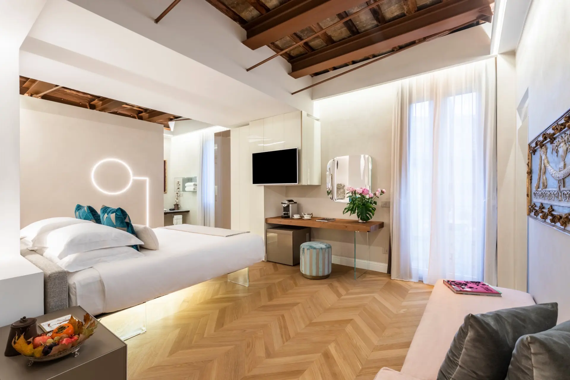 Suite con parquet a spina di pesce e illuminazione scenografica Camera con letto sospeso su base in vetro e testata luminosa a incasso
